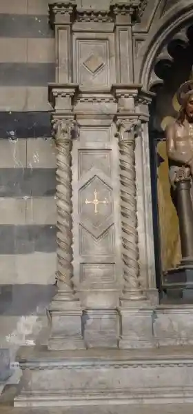 A cross with mini crosses on its arm on the Siena Cathedral